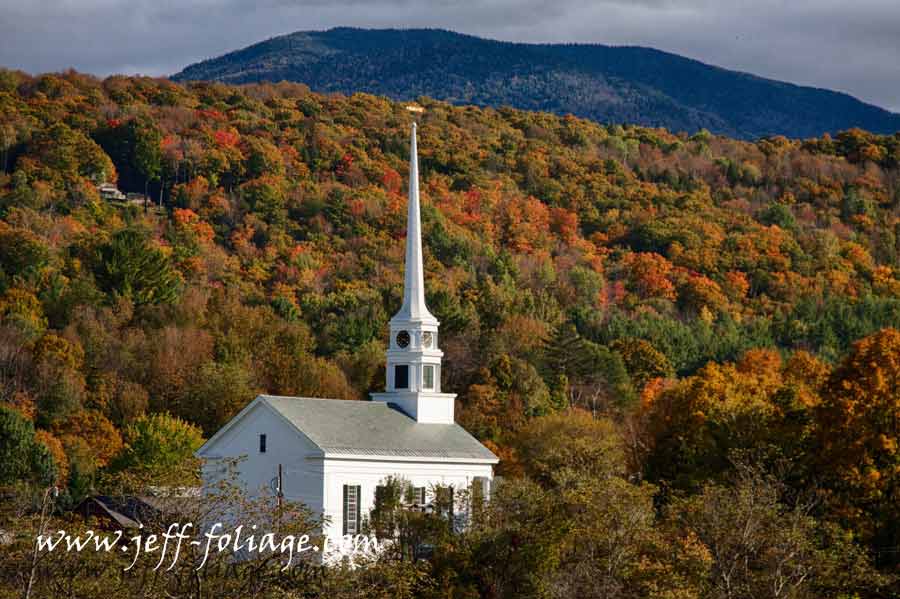 Towering white steeple into fall colors New England fall